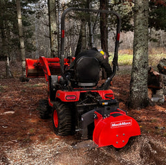 Compact tractor grinding a stump in the woods with the SG24 PTO stump grinder